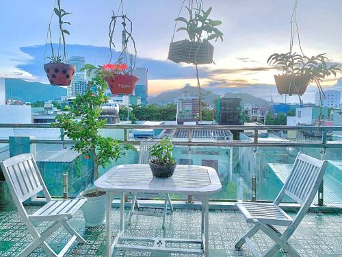 una mesa y sillas en un balcón con macetas en Gia Hoang Hotel, en Quy Nhon