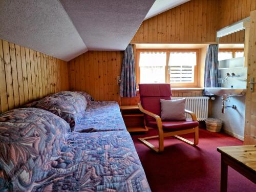 a bedroom with a bed and a chair in a room at 2 Zimmer Ferienwohnung Davos-Glaris in Glaris