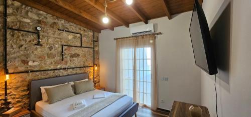 1 dormitorio con cama y pared de piedra en Athens Timeless Escape, en Atenas