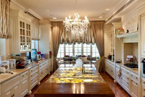 uma grande cozinha com uma mesa de jantar e um lustre em The Dudai Titanic Mansion em Savyon