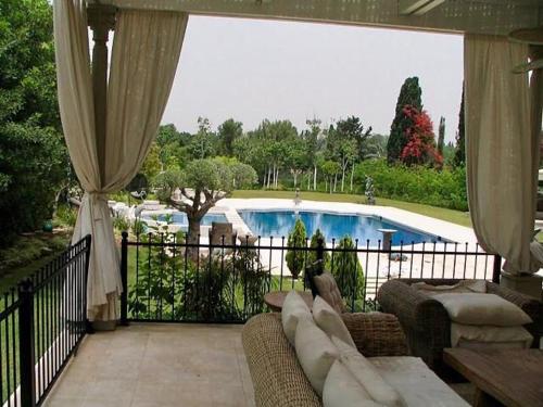 a screened in porch with a view of a swimming pool at The Dudai Titanic Mansion in Savyon