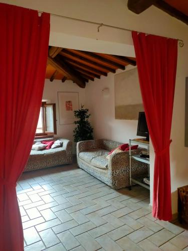 a living room with two couches and red curtains at casadipaola in Gambassi Terme
