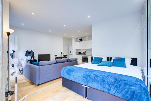 Statera Apartments - City Terraces في لندن: غرفة نوم بسرير واريكة