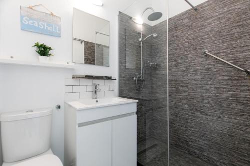 een badkamer met een wit toilet en een glazen douche bij Bela Vista Burgau in Burgau
