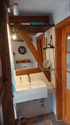 ein Bad mit einem Waschbecken und einem Spiegel in der Unterkunft Kleine gemütliche Ferienwohnung im Fachwerkstil in Wolfsburg