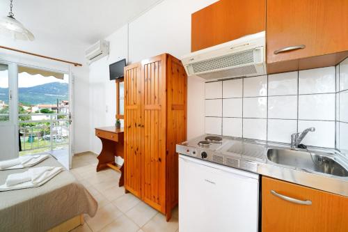a small kitchen with a sink and a bed at Studios Pinelopi in Skala Potamias