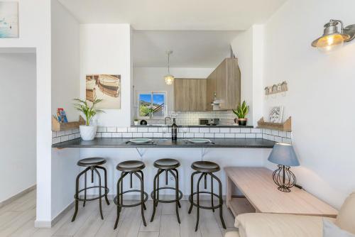 a kitchen with a counter and bar stools at Bela Vista Burgau in Burgau