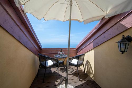 a balcony with a table and an umbrella at Solaria in Amalfi