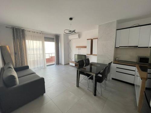 een woonkamer met een bank en een eettafel bij Appartamenti Nicola in Durrës