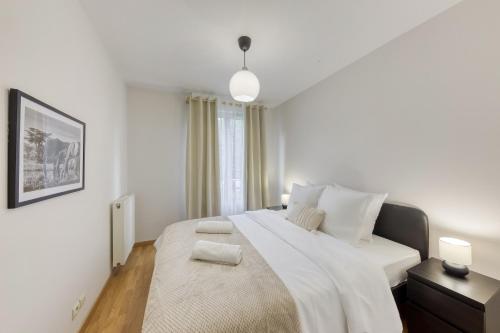1 dormitorio blanco con 1 cama grande y 2 toallas en Lumineux 3 pièces Paris / Disney, en Champs-Sur-Marne