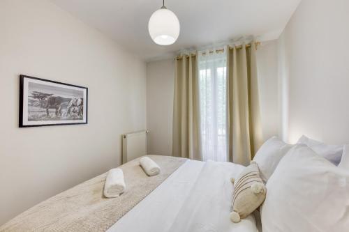 1 dormitorio con 1 cama blanca y 2 almohadas en Lumineux 3 pièces Paris / Disney, en Champs-Sur-Marne