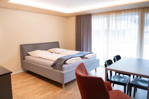 a bedroom with a bed and a table and chairs at WAZ Wohnen auf Zeit - Flums in Flums