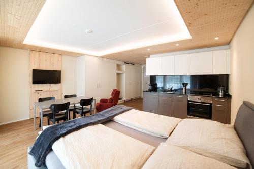 a bedroom with a bed and a kitchen with a table at WAZ Wohnen auf Zeit - Flums in Flums