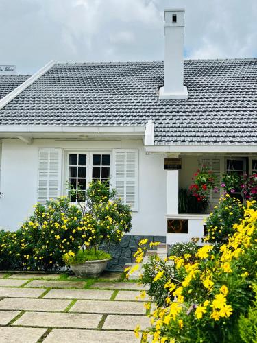 a white house with flowers in front of it at ROY VILLA COFFEE in Da Lat