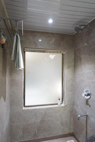 a bathroom with a large mirror on the wall at Treebo Classic Grande, Camp in Pune