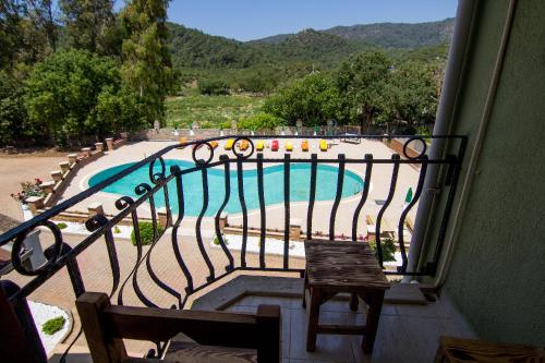 a balcony with a view of a swimming pool at Yeşilkaya Hotel in Kayakoy