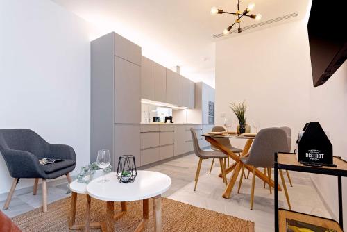 a kitchen and dining room with a table and chairs at Genteel Home Catedral in Cádiz