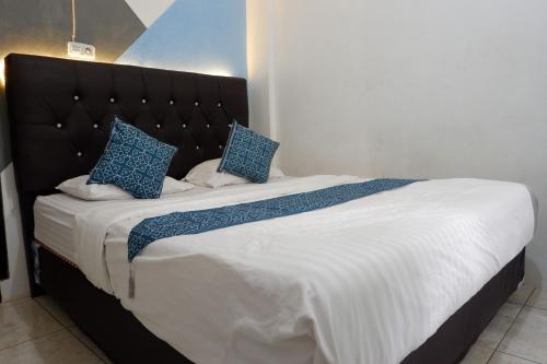 a bedroom with a large bed with blue pillows at Kasmarani Homestay in Palembang