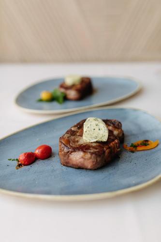 a piece of steak on a blue plate on a table at Hotel Fanat in Split
