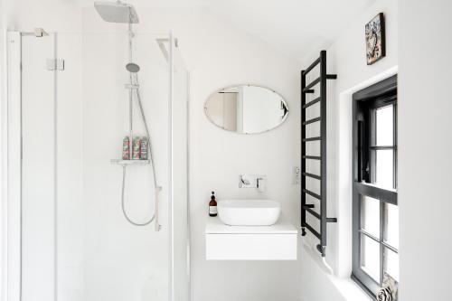 a white bathroom with a sink and a mirror at Verandah Cottage B&B 