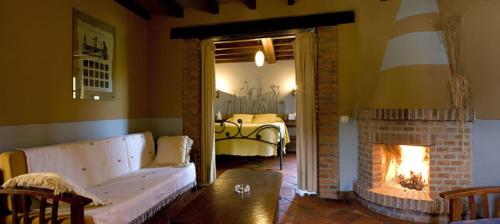 a living room with a bed and a fireplace at HOTEL RURAL ARREDONDO in Celorio