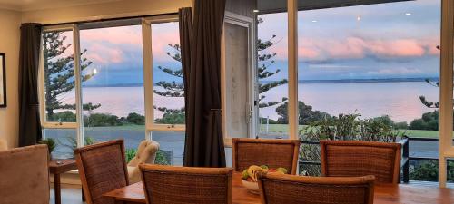 a dining room with a view of the ocean at Captains on the Seafront - Breathtaking Sea views- Large 4br 2bth in Kingscote