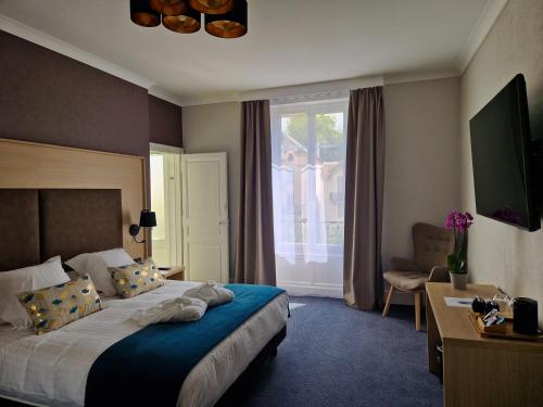 una camera d'albergo con letto e finestra di La Souveraine a Contrexéville