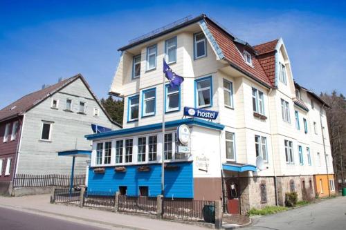 un edificio blu e bianco sul lato di una strada di Hostel & Hotel Braunlage a Braunlage