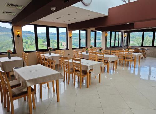 a dining room with tables and chairs and windows at The Hill in Veliko Tŭrnovo