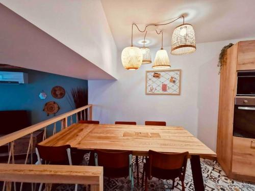 une salle à manger avec une table et des chaises en bois dans l'établissement Gîte de l’Ancien Puits, à Saint-Bauzille-de-la-Sylve