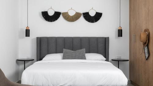 een slaapkamer met een wit bed met een zwart hoofdeinde bij Big studio with Balcony 100M from the beach - By Edom in Eilat