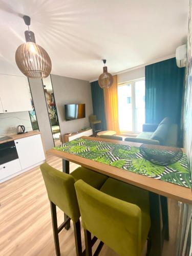 a living room with a dining room table with green chairs at Apartamenty Białe nad jeziorem Białym in Augustów
