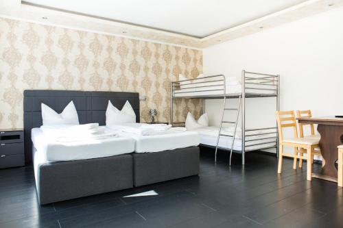 a bedroom with two beds and a bunk bed at Hostel & Hotel Braunlage in Braunlage