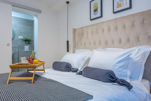 a bedroom with a bed with pillows and a table at Luxury Kvarner Park Villa with garden and large RGB private pool in Kastav