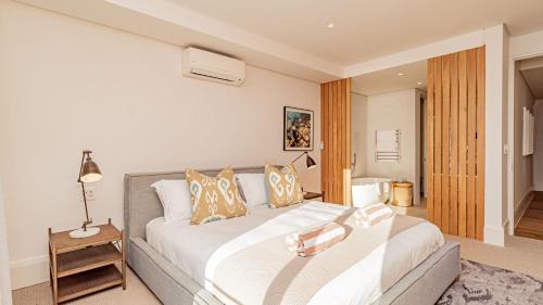 um quarto com uma grande cama branca num quarto em Alpha Sunsets em Cidade do Cabo