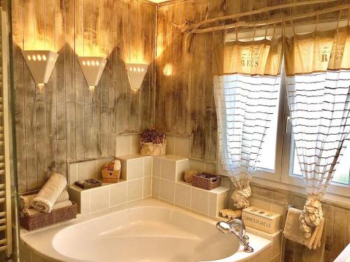 une baignoire dans une salle de bain avec une fenêtre dans l'établissement La Maison du Bonheur F5 jardin et piscine, à Narbonne