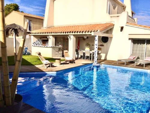une piscine devant une maison dans l'établissement La Maison du Bonheur F5 jardin et piscine, à Narbonne
