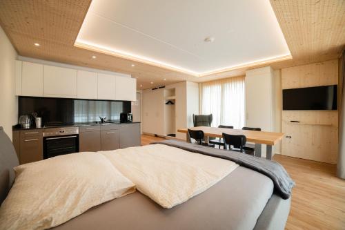 a bedroom with a large bed and a table with chairs at WAZ Wohnen auf Zeit - Flums in Flums