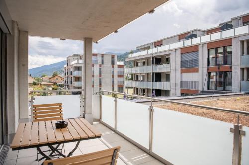 a balcony with a table and chairs and buildings at WAZ Wohnen auf Zeit - Flums in Flums