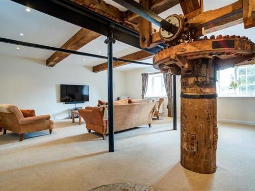 a living room filled with furniture and a wooden beam at Arlington Mill in Cirencester