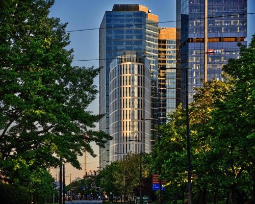 a tall glass building in front of a city at Holiday Inn Express - Warsaw - The HUB by IHG in Warsaw