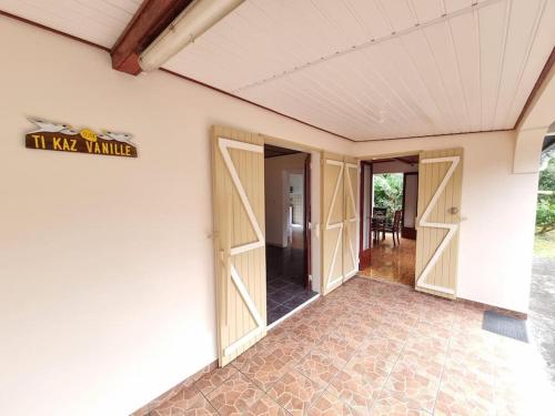 een kamer met openslaande deuren naar een kamer met een tafel bij Ti kaz Vanille in Saint-Philippe