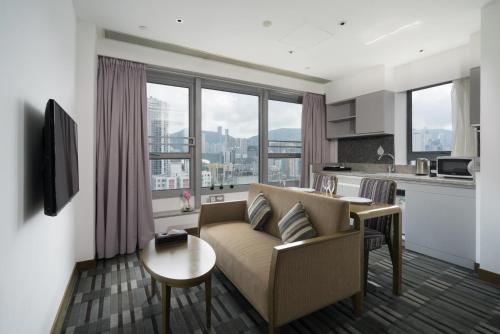 een woonkamer met een bank en een tafel bij Hotel One Eighteen in Hong Kong