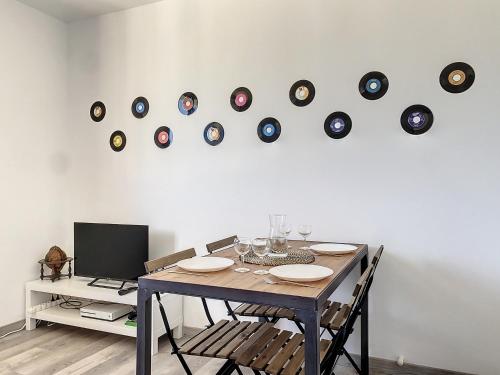 une table à manger avec un bouquet de disques sur le mur dans l'établissement La Perle Marseillaise - Central & Lumineux - Les Frères de la Loc', à Marseille