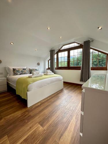 a large bedroom with a large bed and wooden floors at 4 Sheraton Apartments in Fort William