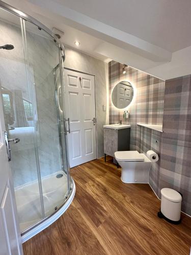 a bathroom with a shower and a toilet and a sink at 4 Sheraton Apartments in Fort William