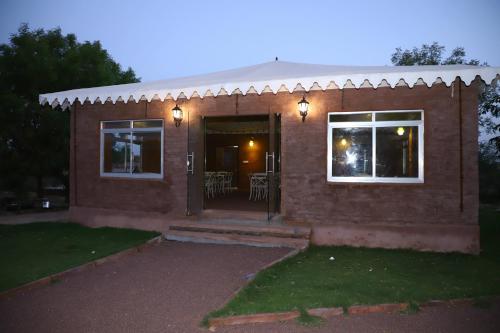 a brick house with a door and windows at night at Impian Resorts - Jodhpur in Jodhpur
