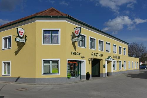 un gran edificio amarillo con una tienda delante en Hofmanns B&B en Loosdorf