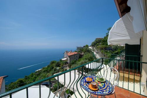 a balcony with a table and a view of the ocean at Solaria in Amalfi