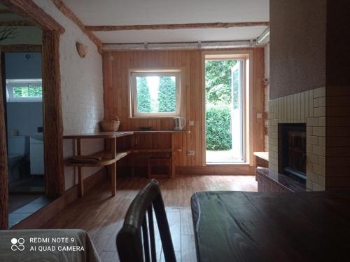 a living room with a fireplace and a window at Садиба Живиця in Kozlin